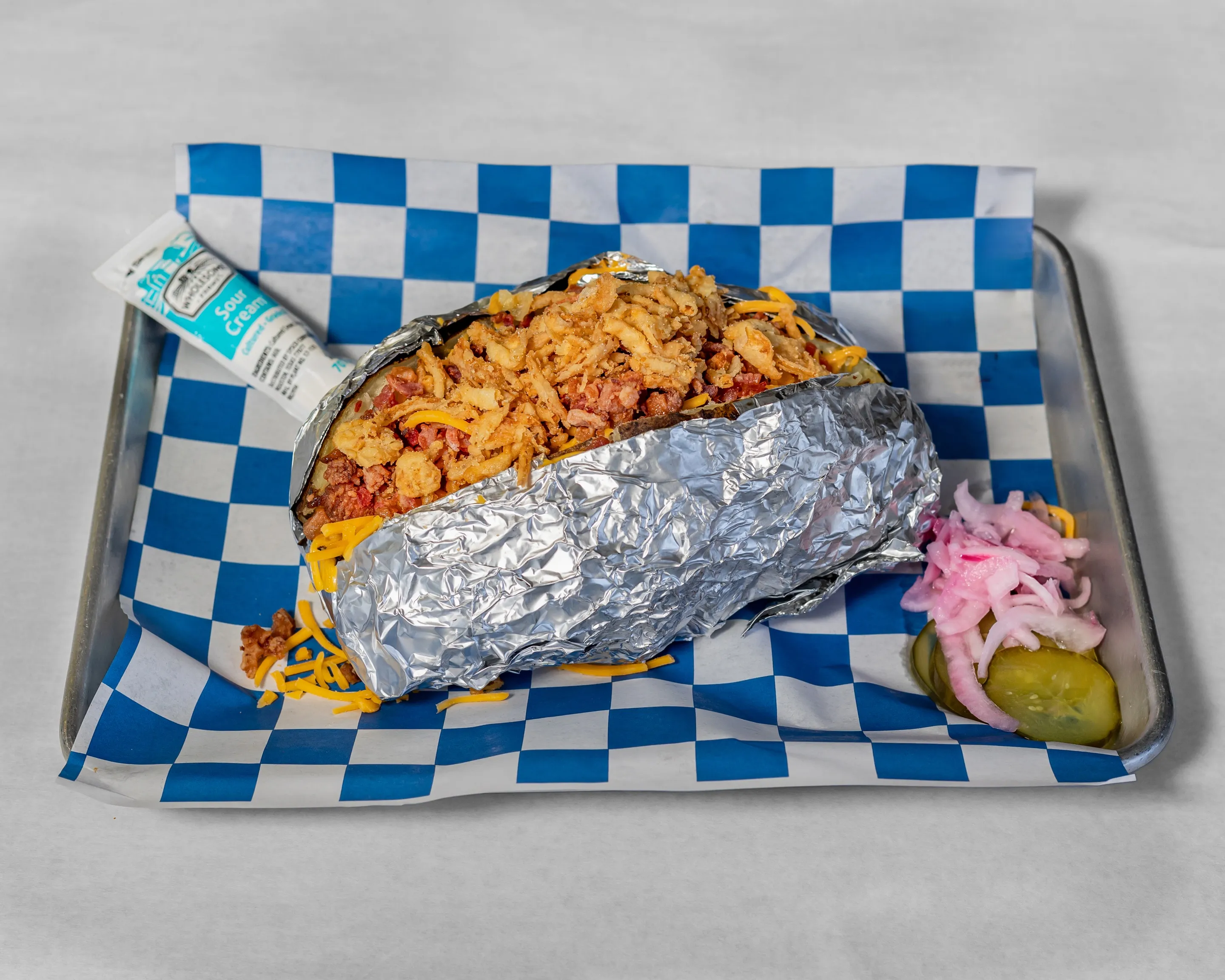 Loaded smoked baked potato from Timmy Jon’s BBQ in Dade City, FL, topped with brisket, cheese, and sour cream